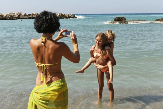 Mutter macht Bilder von Kindern im Familienurlaub auf Kreta