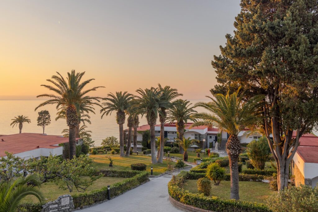 Blick auf einen Bungalow im Aldiana Club Rocca Nettuno. Im Hintergrund ist das Meer zu sehen.