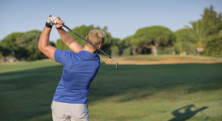 Golfer von hinten zu sehen beim Abschlag