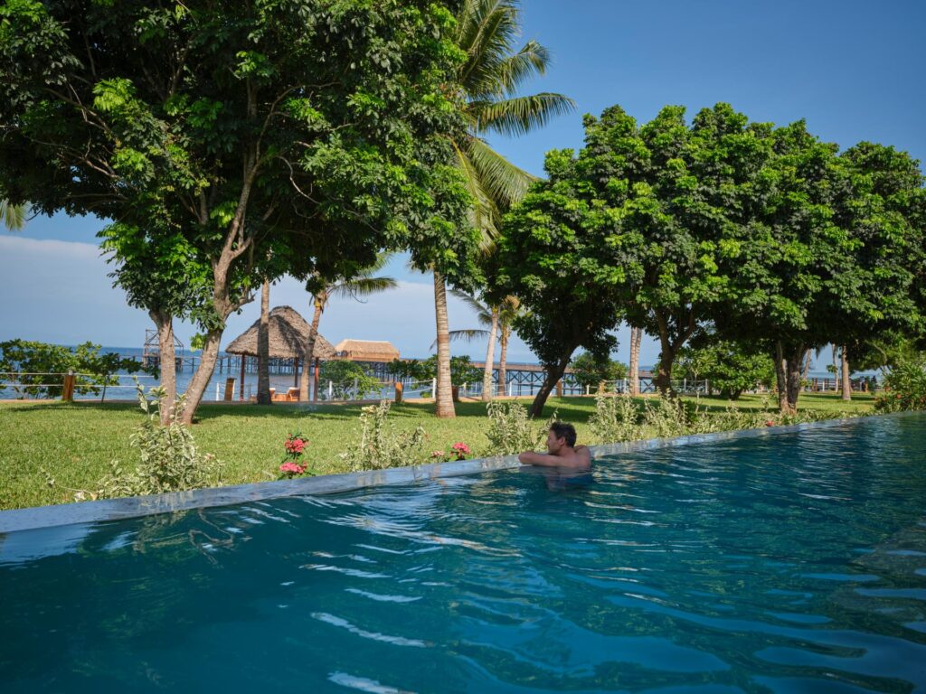 Ein Mann genießt den Ausblick vom Pool aus aufs Meer. Im Aldiana Club Zanzibar Kwanza.