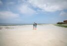 Paar spaziert am Strand von Sansibar