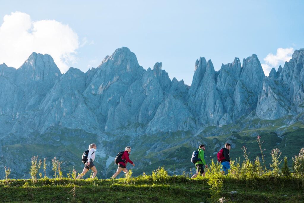 Eine Gruppe aus zwei Frauen und zwei Mändern wandert in den Bergen. 
