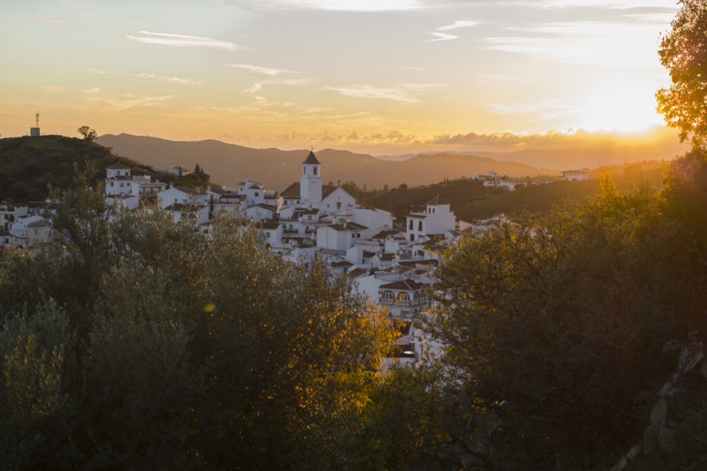 Blick auf ein weißes Städtchen durch goldgelbe Wälder im Herbst von Andalusien. 