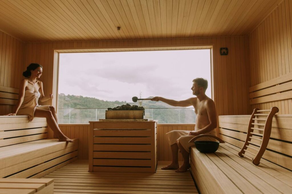 Mann und Frau genießen die Sauna mit Blick auf die Natur.