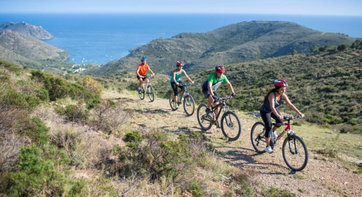 Radfahrergruppe genießt Mountainbike-Tour mit Meerblick.
