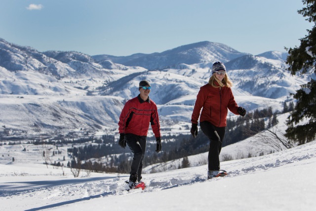 Zwei Personen wandern mit Schneeschuhen in den Bergen.
