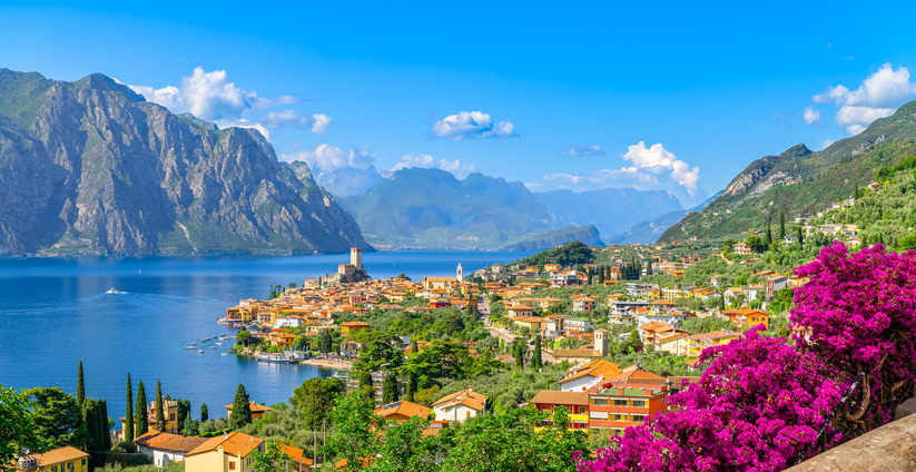 Perfekt für die Hochzeitsreise nach Italien lädt die Stadt Malcesine am Gardasee ein. Das Bild zeigt ein wunderschönen Panorama Blick von der Stadt Malcesine am Gardasee. Malcesine liegt inmitten der Natur des Sees und in den Bergen.