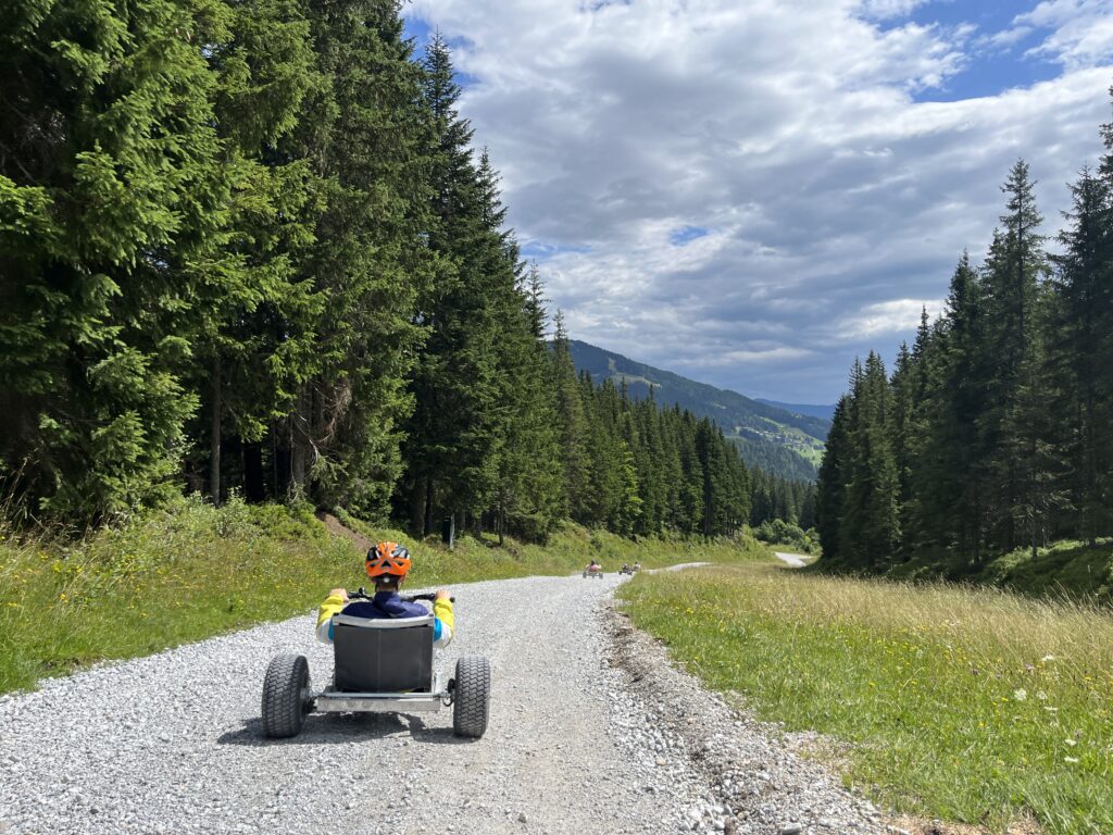 Ein Mann fährt mit einem Mountain Cart den Berg hinunter. 