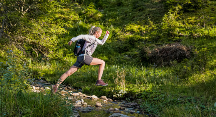Eine Frau die in Österreich im Sommer trailrunning macht