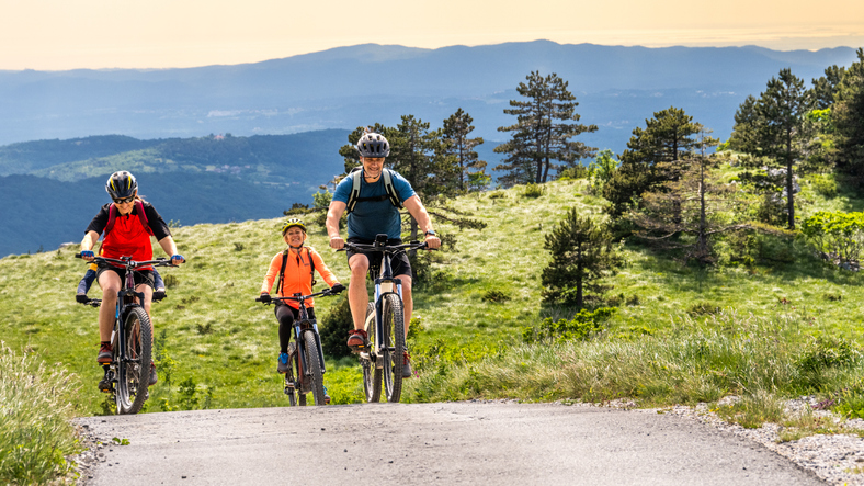 Radfahren mit der ganzen Familie in den Bergen von Österreich. 