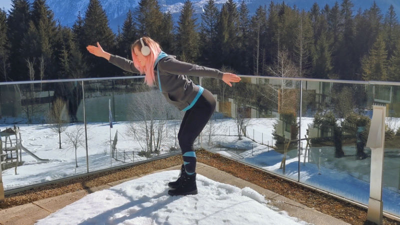 Eine Frau schwingt die Arme als Skigymnastik-Übung zum Aufwärmen