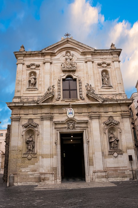 Die Kathedrale San Cataldo von vorne. Blauer Himmel im Hintergrund, gemauertes Gebilde mit großer geöffneter Eingangstür