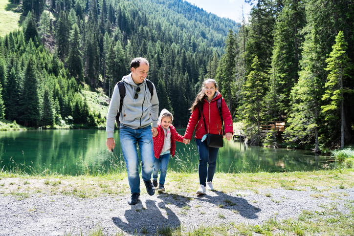 Wandern mit der ganzen Familie entlang eines Sees im Sommer in Österreich. 